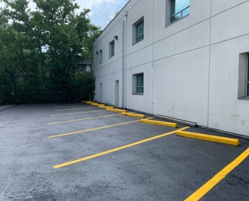 Image depicts freshly painted parking lines in a commercial parking lot.