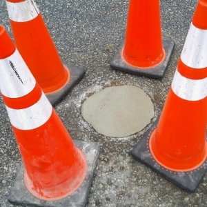 Image depicts a pothole in a commercial driveway.