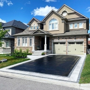 Image depicts a home with a driveway that has been recently sealed.