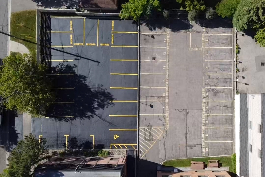 Image depicts a commercial parking from a recent asphalt sealing and line painting project by AHS.