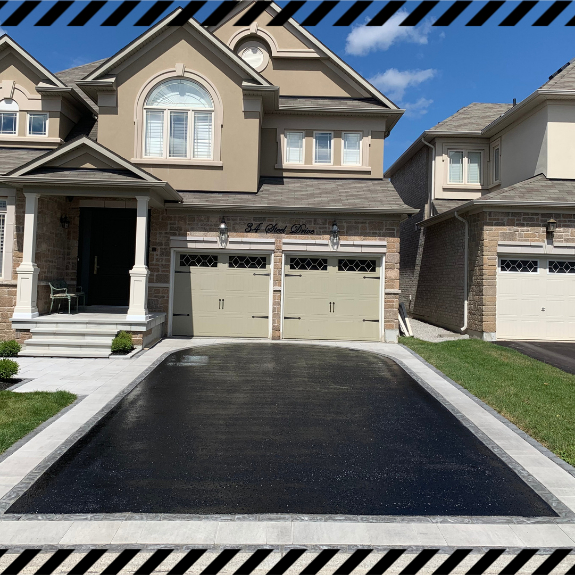 Image depicts a driveway that has been sealed as part of a driveway sealing Maple project.