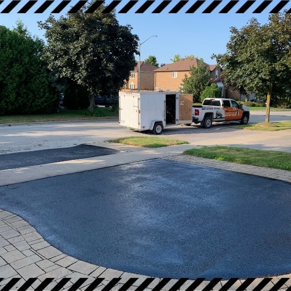 Image depicts a driveway that has been sealed as part of a driveway sealing Oakville project.